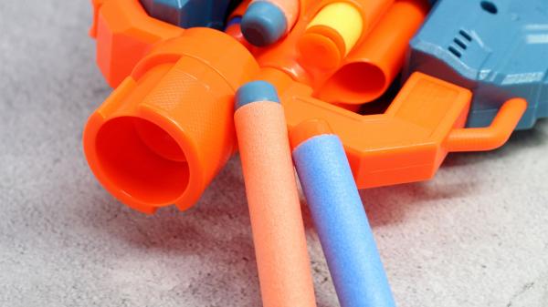 Orange and blue Nerf blaster with colorful foam darts.