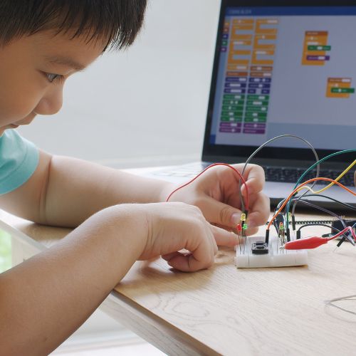 Young boy experiments with circuits and Scratch coding.