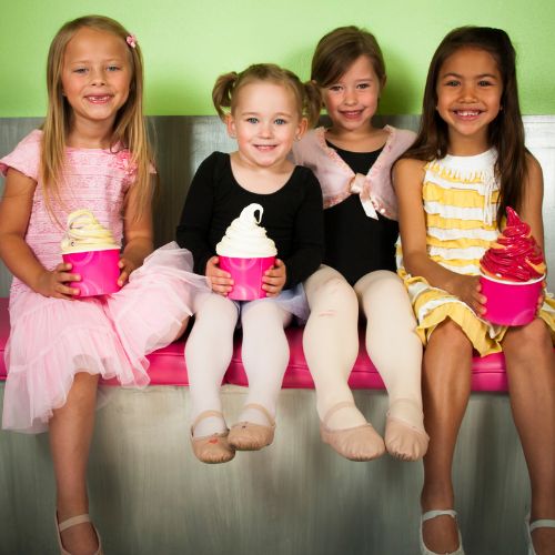 Young girls sitting together with ice cream.