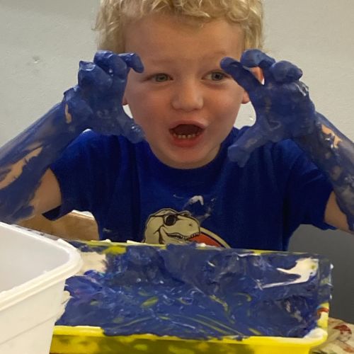 Young boy fingerpainting with blue paint