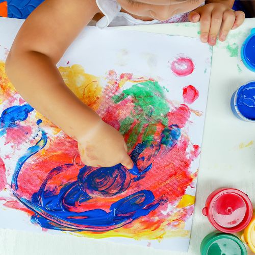 Young child finger painting.