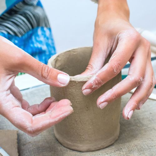 Teen creating pottery by hand.