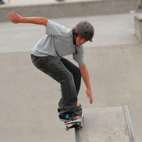 Teenager riding skateboard in skate park.